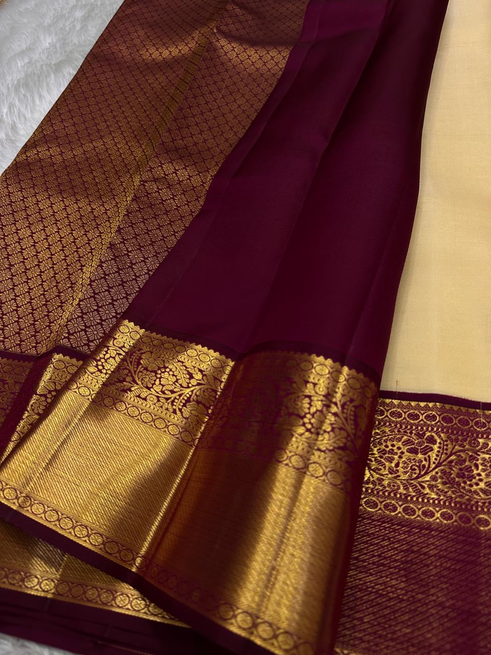 Ragini – Ivory & Gold Kanchipuram Pure Silk Saree with Floral Jaal & Maroon Baavanji Border
Timeless elegance shines through the delicate ivory base and shimmering gold zari floral jaal. The rich maroon Baavanji border and intricate pallu details complete