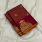 Folded maroon vairaoosi zari kattam Kanchipuram silk saree with gold elephant buttas and wine border on white fabric.