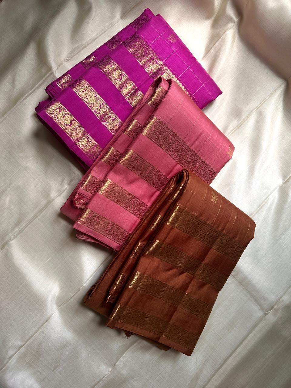 vasantham  Fuchsia pink – Handwoven Kanchipuram Silk Saree A poem in Fuchsia silk. The body glows in a serene vibrant Fuchsia, softly accented by delicate gold vertical lines and dainty gold zari buttas that glint like little blessings.