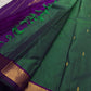 Varnam is a pure Kanchipuram silk saree in rich emerald green with subtle dual-tone shading. Woven gold zari buttas dot the body, while a petite purple border woven with intricate zari adds refined contrast. Arai maadam Pallu, jewel toned classic !