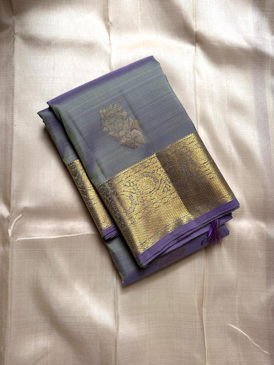 Dia ✨ – Unique Ash Lilac Grey Kanchipuram Pure Silk Saree
Gold Zari Buttas Adorning the Body
Intricate Gaja–Annam (Elephant & Peacock) Motif Border
Coordinated Ash Lilac Grey Silk Blouse Piece Included
Silk Mark Certified | Fall & Pico Done