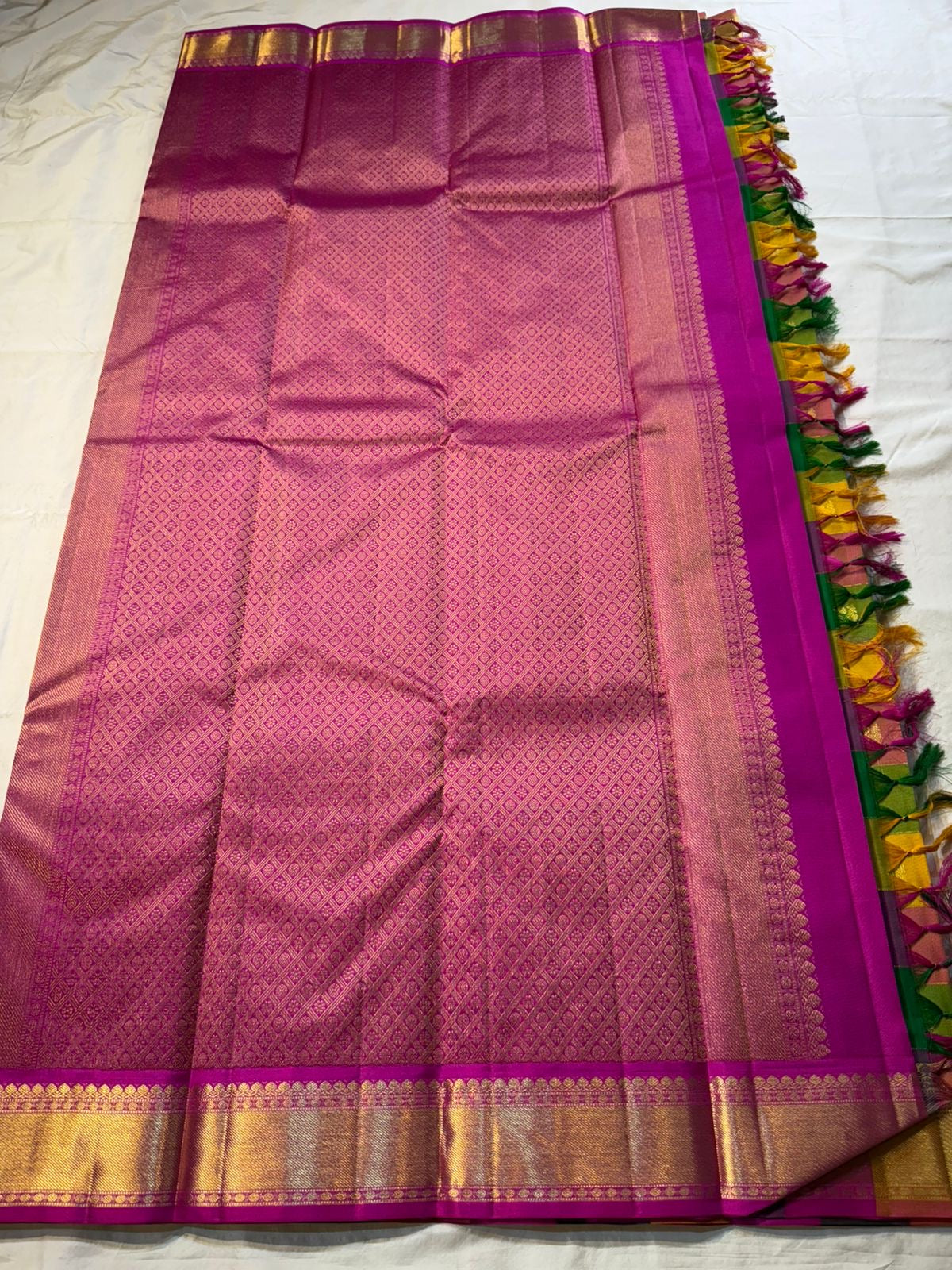 Pallavi – Kanchipuram Paalum pazhamum checks/ Zari kattam  Silk Saree in Turmeric, Mango, Leaf Green & Beetroot Pink Checks.
Finished with a vibrant magenta border and rich gold zari pallu.