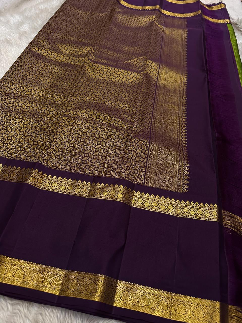 Iravati – Earthy Green Kanchipuram Pure Silk Saree
A graceful weave in a rare earthy green tone, adorned with gold zari kattam and butta.
Accented by a rich plum rettapet border with delicate flower vine motifs.