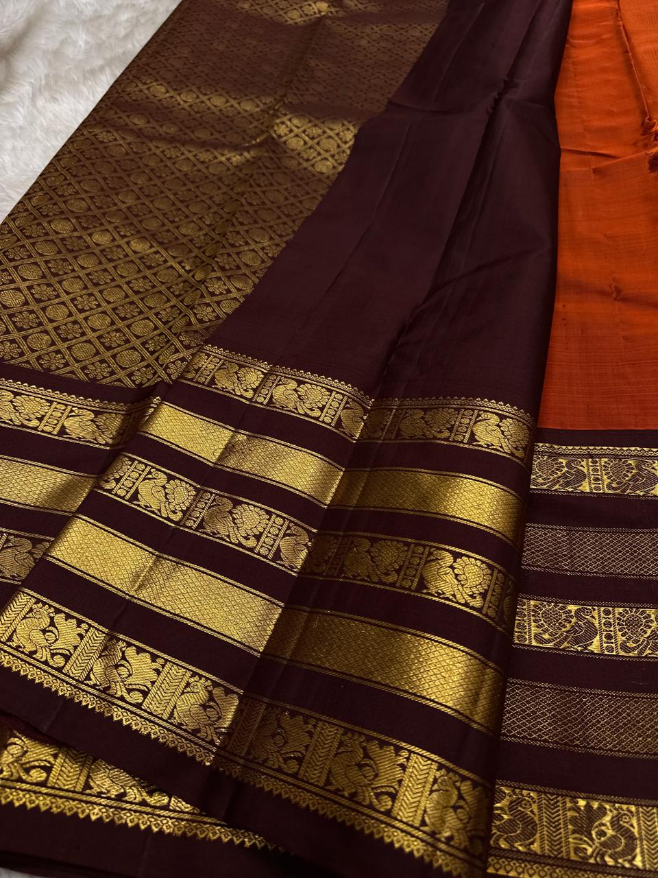 Ember Yazhi – Pure Kanchipuram Silk Saree
Burnt Orange Body with Vaira Oosi Stripes & Yazhi Buttas
Contrast Maroon Varisaipet Border with Gold Zari Panels
Grand Maroon Brocade Pallu with Intricate Motifs

Silk Mark Certified, delivery in 2 weeks