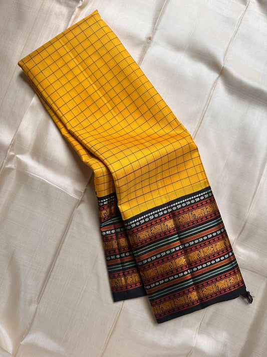 Marigold Mani Kattam – Pure Kanchipuram Silk Saree
Vibrant marigold yellow body with classic kattam checks
black borders with elephant & floral zari motifs
Rich black pallu adorned with green & zari stripes . Silk Mark Certified, delivery in 2 weeks