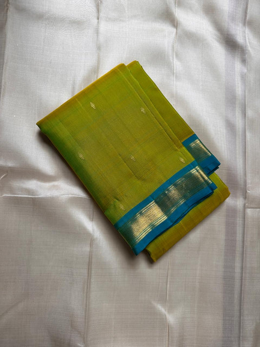 Citrus and Teal – Pure Kanchipuram Silk Saree
Dual-tone body in parrot green and turmeric.
Elegant gold leaf buttas across the drape.
Teal korvai border
Rich teal pallu with diamond jaal and temple motifs.

Silk Mark Certified, delivery in 2 weeks
