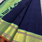 A striking blend of tradition and bold design, this navy blue Kanchipuram silk saree features delicate grid-like checks across the body. What sets it apart is the vibrant mint green and gold zari border, intricately woven with paisley and floral motifs