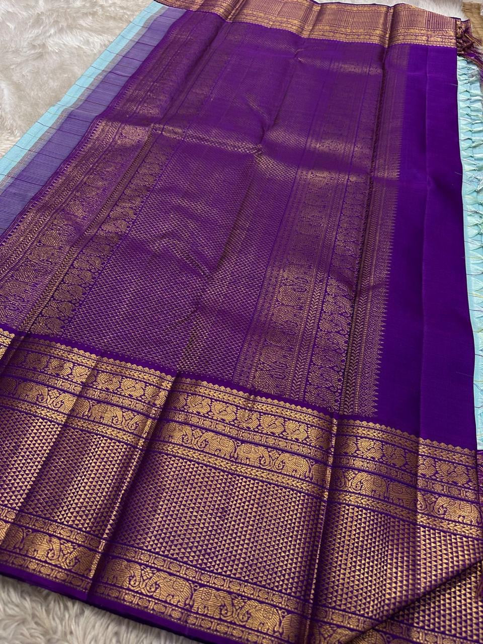 Aakasa Kattam — Pure Kanchipuram Silk Saree
Sky-aqua body with fine kattam checks in lemon and violet, adorned with silver-zari paisley buttas and contrast purple brocade borders.
Silk Mark Certified • Free Shipping within USA • Dispatch in 1 Week • Ships