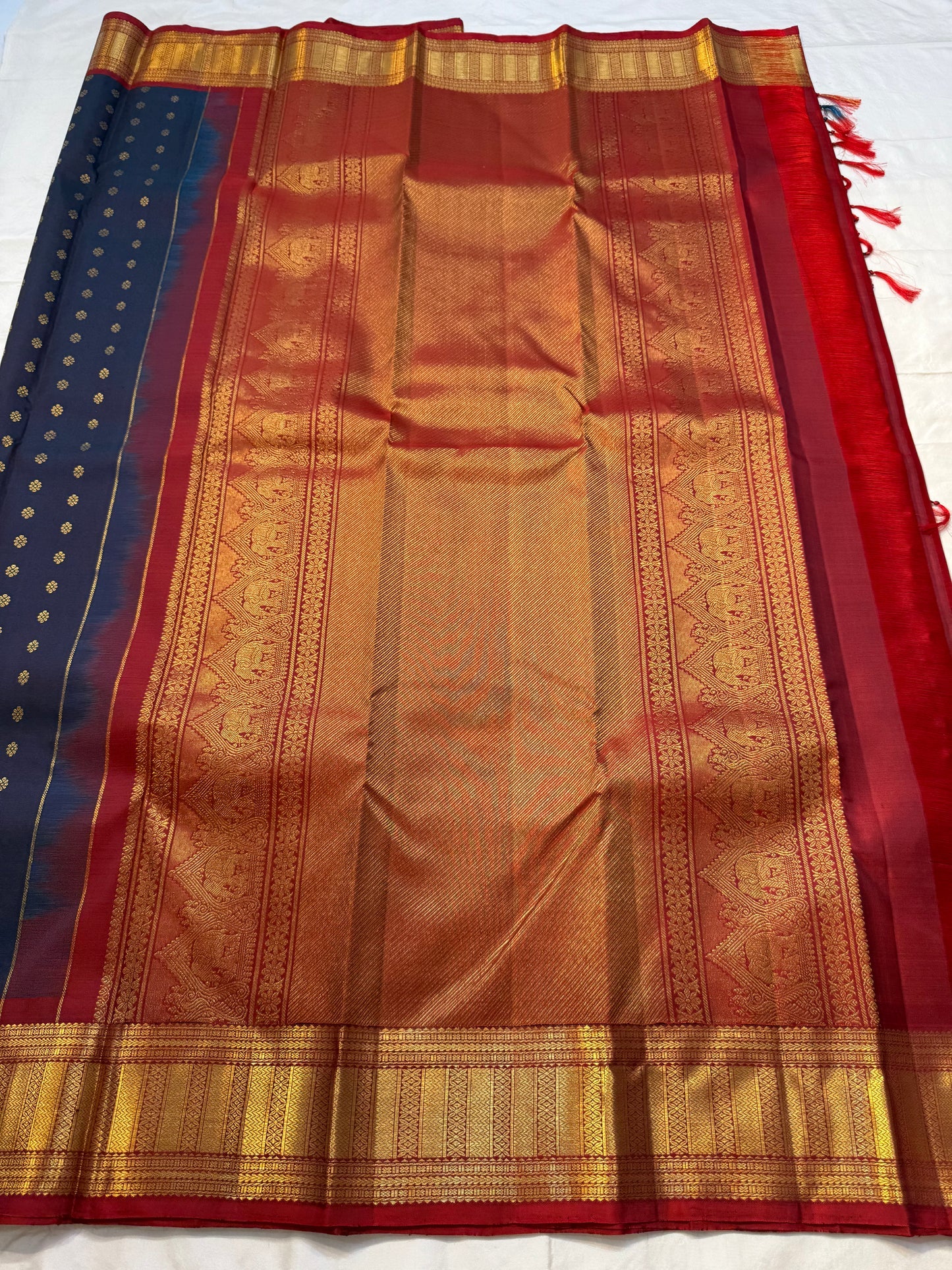 Midnight Neelam Flower Butta — Kanchipuram Pure Silk


Deep midnight neelam (navy) body with scattered gold flower buttas

Korvai contrast maroon borders with grand + geometric zAri motifs 

Rich zari pallū with ornamental motifs; hand-twisted tassels