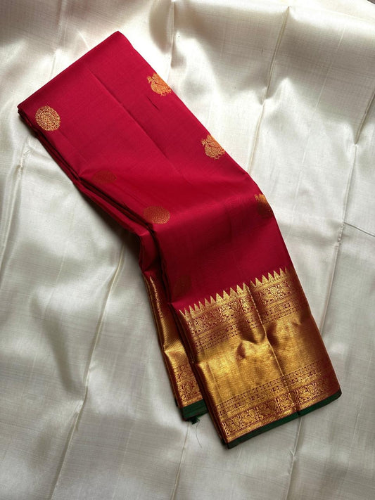 A timeless drape in sindoor red and betel leaf green emerald grace! Mayil chakram butta peacock border