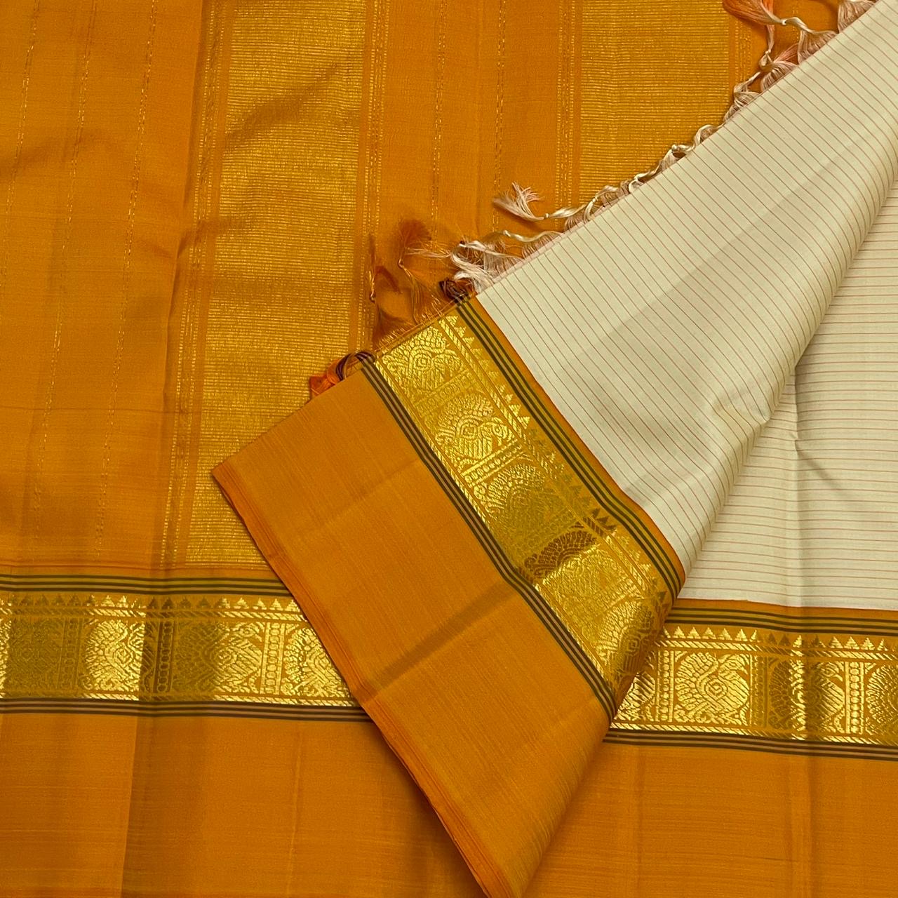 Sweta Kanakam Kattam — Pure Kanchipuram Silk Saree
Ivory Pinstripes × Marigold border with Antique-Gold Zari Border
Silk Mark Certified • Free Shipping within USA • Ships in Two Weeks