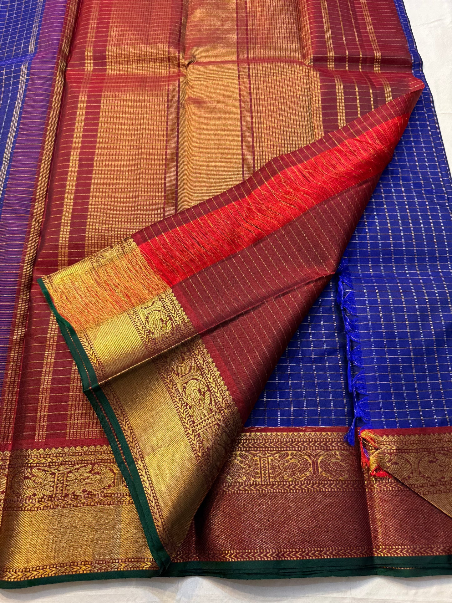 Neela Ratnam — Pure Silk Kanchipuram

• Cobalt-blue kattam checks with antique-gold zari

• Ruby-maroon contrast pallu with grand zari work

• Floral vine borders with bottle-green selvedge

• Silk Mark Certified • Ships in Two Weeks • Free Shipping withi