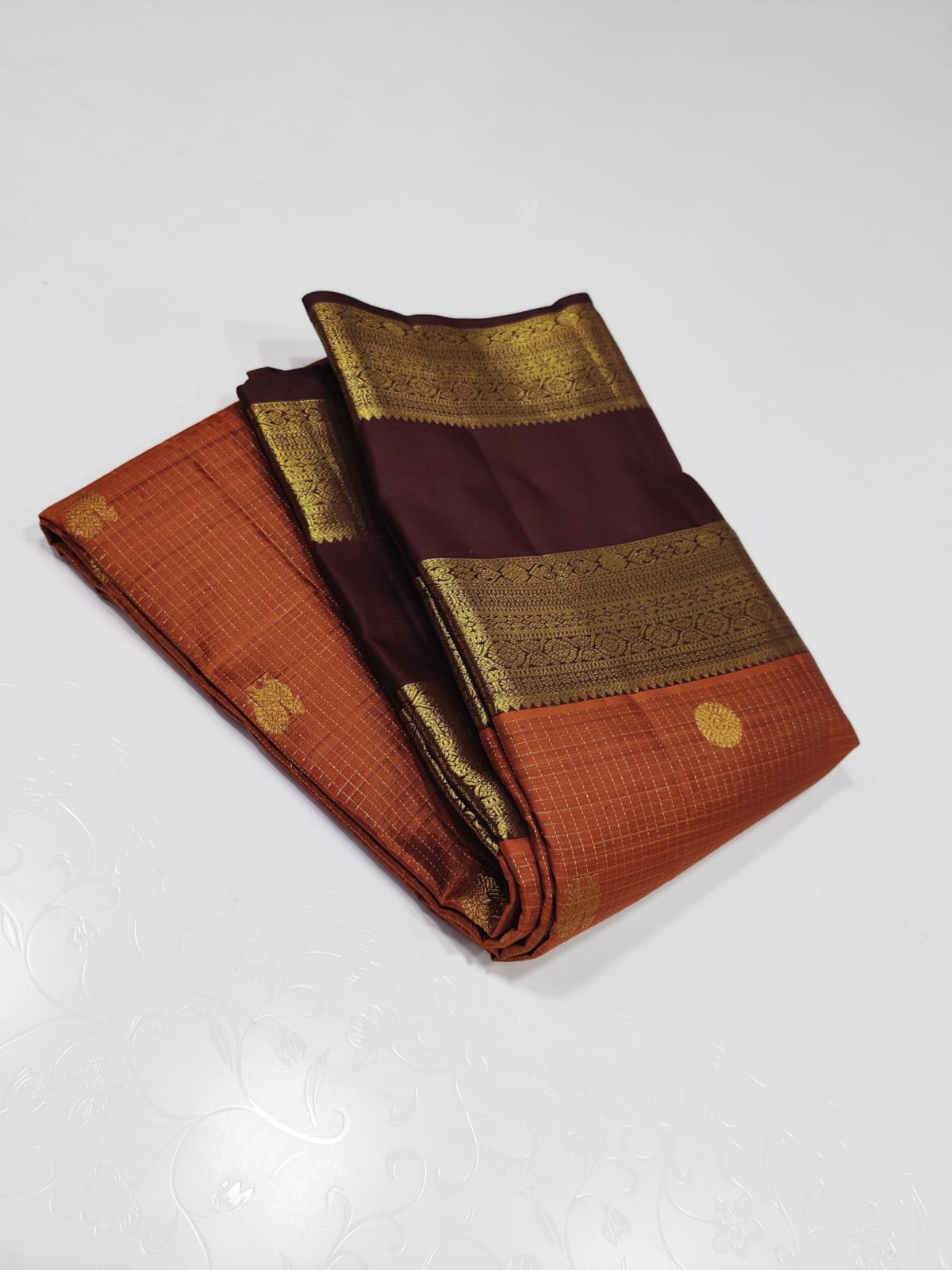 Burnt orange pavun butta – Pure Kanchipuram Silk Saree
Burnt Orange  body adorned with delicate kattam checks ✨
Scattered gold medallion buttas add timeless temple elegance

Silk Mark Certified, delivery in 2 weeks