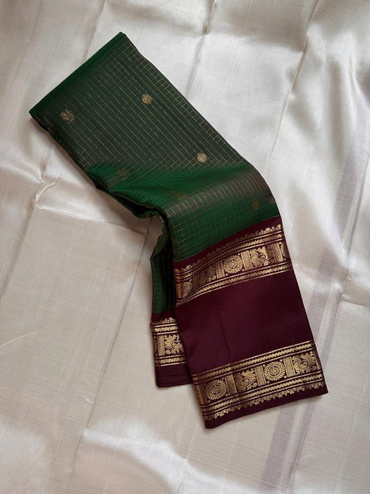 Geetham ✨
Forest Green Zari Kattam Pure Silk Kanchipuram Saree 🌿
With Ornate Rettapet Border of Peacock & Kamalam Motifs 🦚🌸
Flanked by Muthuseer Florals & Vanki Neli Columns 🌺
Finished with a Grand Brocade Maroon Pallu in Rich Zari ✨