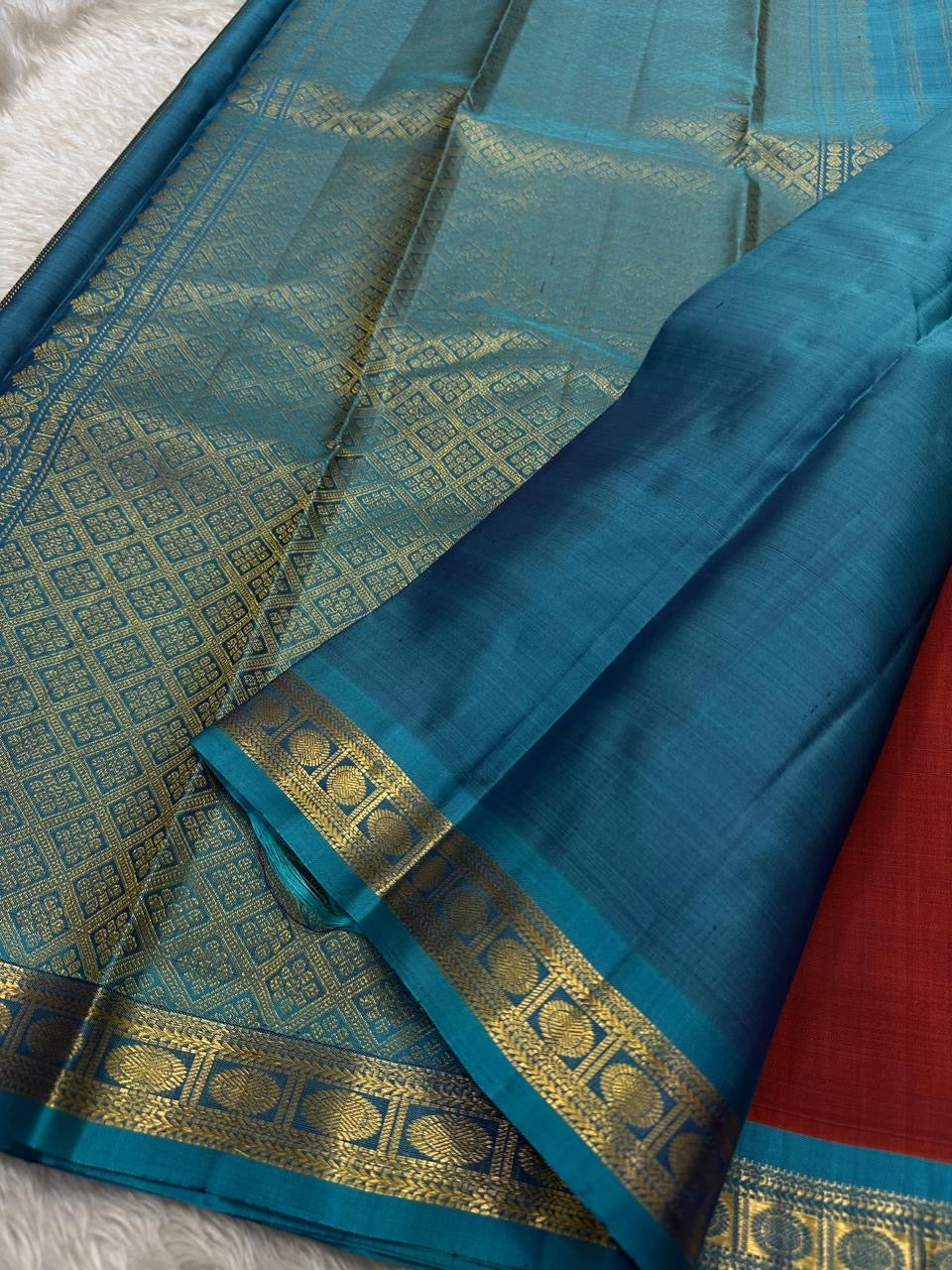 Komethagam Rama ✨
Pure Kanchipuram Silk Saree in Ember Red & Rāmar Blue
Ember-red body with gold zari buttas – gemstone inspired
Contrast Rāmar-blue border with chakra & vine motifs

Silk Mark Certified, delivery in 2 weeks