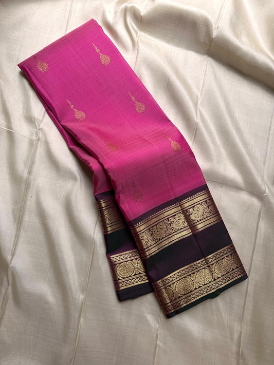Anvitha – Magenta & Pink Shot Kanchipuram Pure Silk Saree
Glowing dual-tone silk body in radiant magenta and pink
Paired with a rich brown rettapet border featuring peacocks & floral vines in gold zari