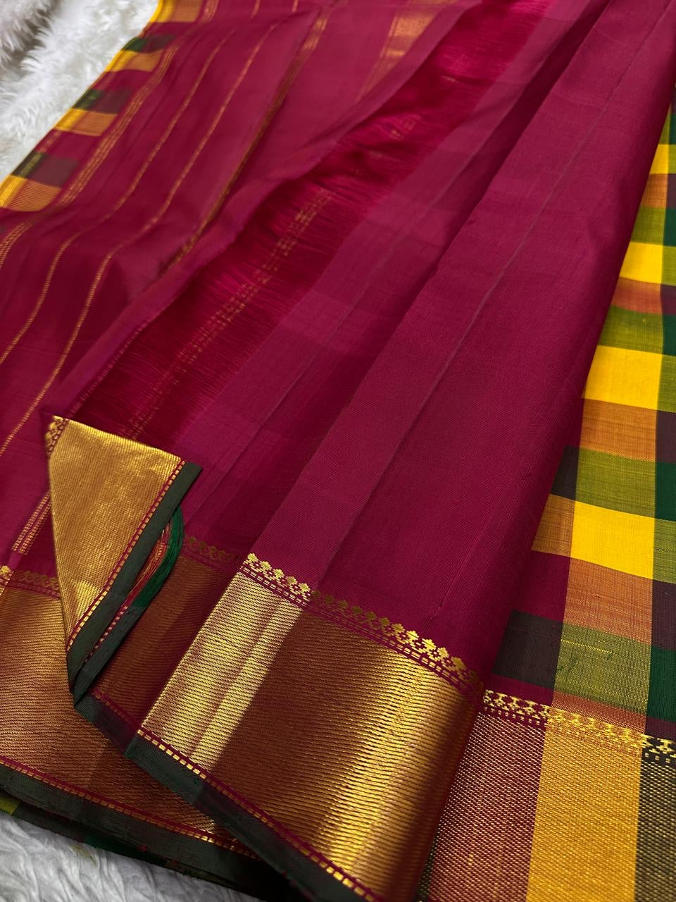 Wine pallu detail with zari woven stripes and broad gold zari border with green contrast edge
