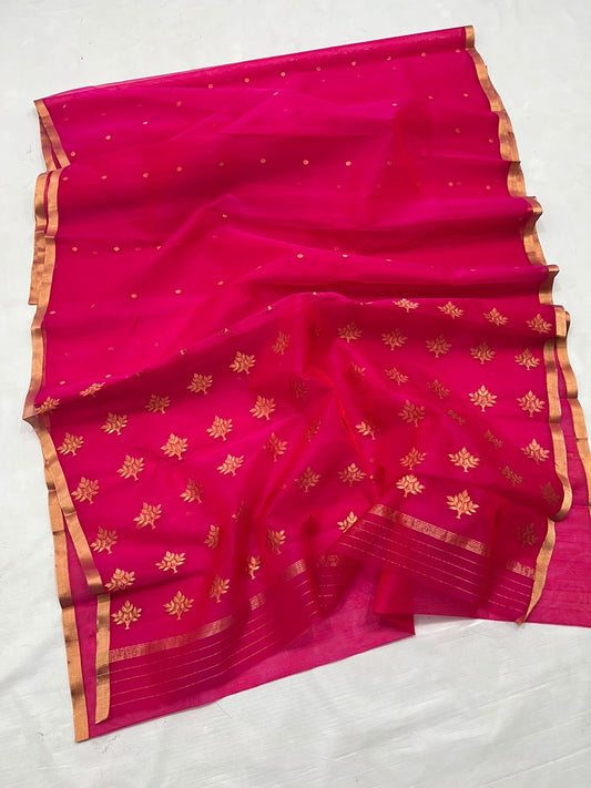 A timeless classic, this Rani pink Chanderi silk saree is a celebration of heritage and elegance. Crafted from lightweight silk with a luxurious sheen, the saree features all-over gold zari floral leafy buttas