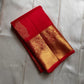 A traditional Kanjivaram (Kanchipuram) silk saree, vibrant red orange peacock floral motifs bavanji border and ornate grid motif Pallu