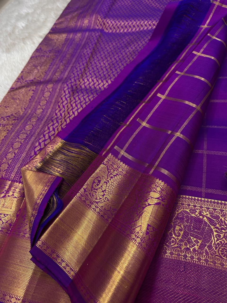 Amethyst Gandaberunda Kamalam – Pure Kanchipuram Silk Saree

Amethyst Purple Body with Zari Kattam Checks & Lotus Buttas

Grand Antique-Gold Borders with Gandaberunda & Peacock Motifs

Purple Zari Brocade Pallu

Silk Mark , ships in 2 weeks