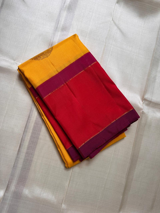 Mustard yellow silk saree fold with zari woven coin buttas and magenta border