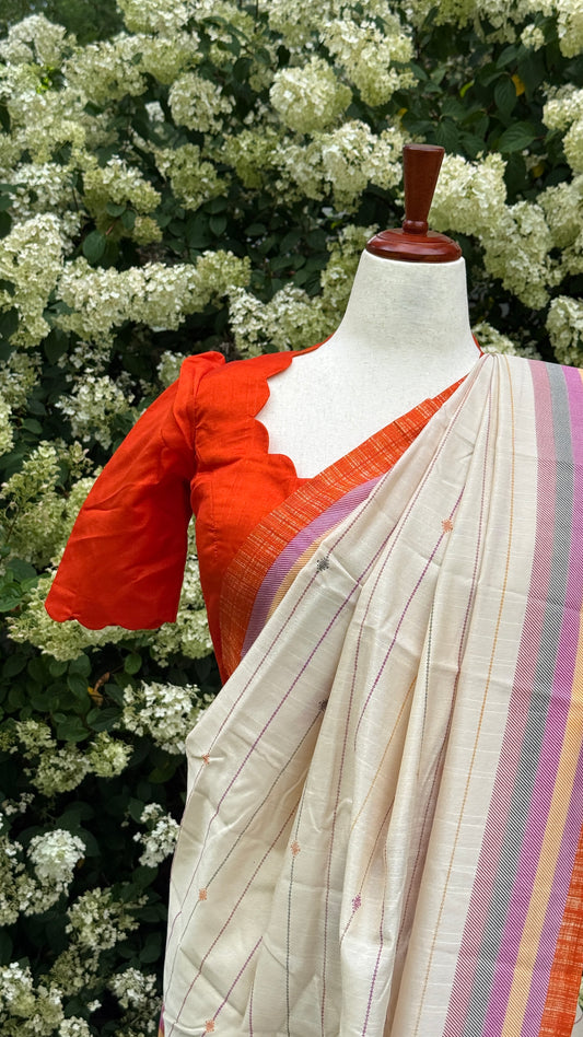 Tamara – Ivory Cream Semi-Silk Saree with Vibrant Orange Border
Paired with a Scallop Neck & Sleeve Ready-to-Wear Orange Blouse (Size 36–42)