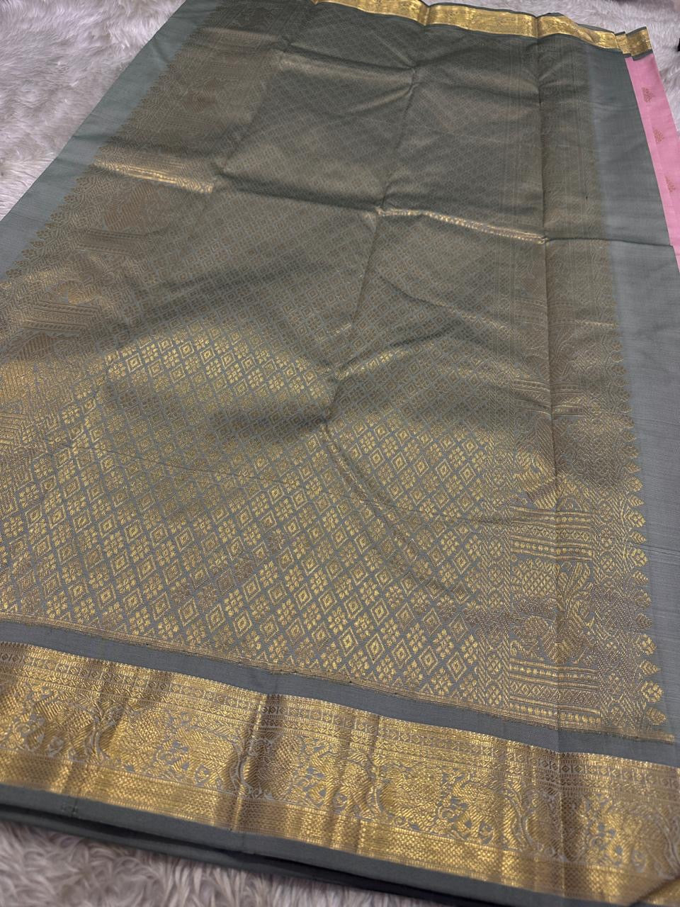 Blush Ash Mayil – Pure Korvai Kanchipuram Silk Saree
Soft blush-pink body with gold zari paisley buttas for a delicate look
Contrast ash-grey border with peacock & floral vine motifs in zari
Grand ash-grey brocade pallu with intricate … chk description