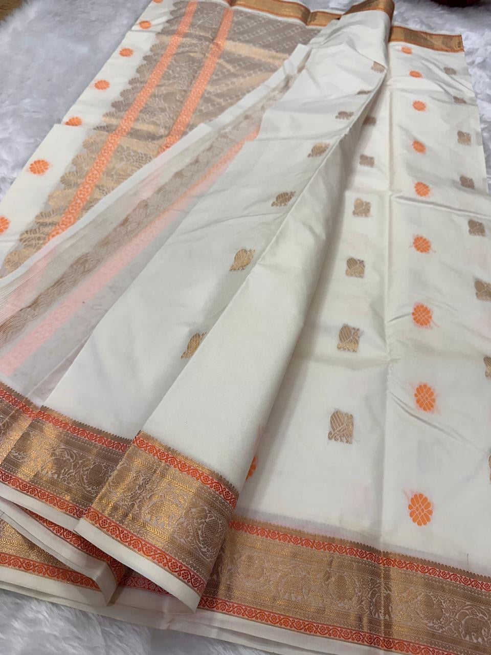 Ivory Swarna — Pure Kanchipuram Silk Saree
Ivory body with marigold rosette and antique-gold paisley buttas, framed in champagne-gold elephant brocade borders.
Silk Mark Certified • Free Shipping within USA • Dispatch in 1 Week • Ships in Two Weeks ✅