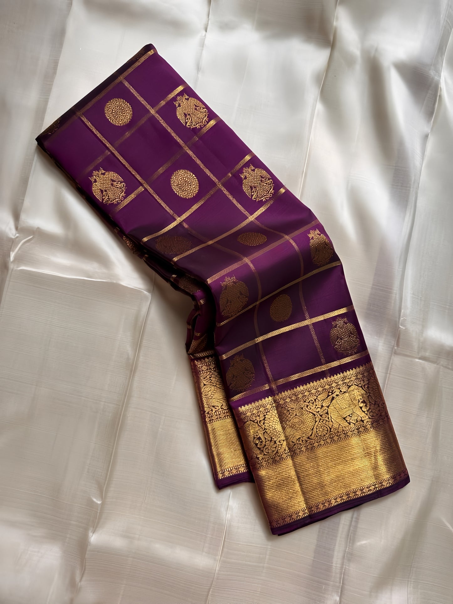 Nayaki ✨ — Deep Jamun (Naaval Pazham) Pure Silk Saree
With Zari Kattam Checks Across the Lustrous Body
Featuring Rare Gandaberunda Motifs in Gold Zari
Broad Elephant-Adorned Border in Heritage Weave
Grand Jamun Pallu with Rich Zari Brocade Artistry