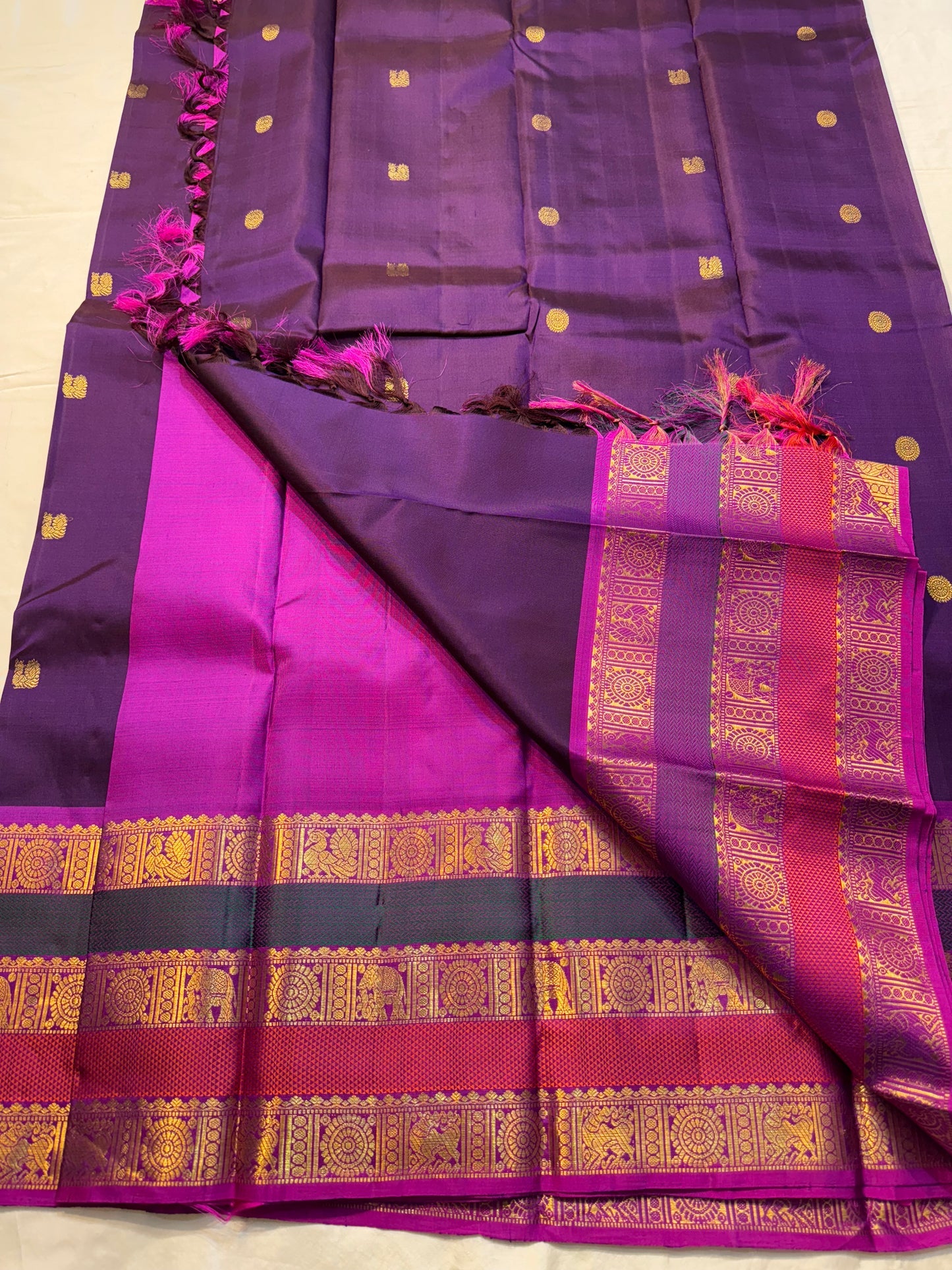 Madhurima — Pure Kanchipuram Silk (Royal Purple × Magenta)
Royal purple body with gold coin buttas, magenta korvai border with zari-woven elephant & peacock panels, and rich magenta pallu.
Silk Mark Certified • Free Shipping within USA • Ships in Two Week