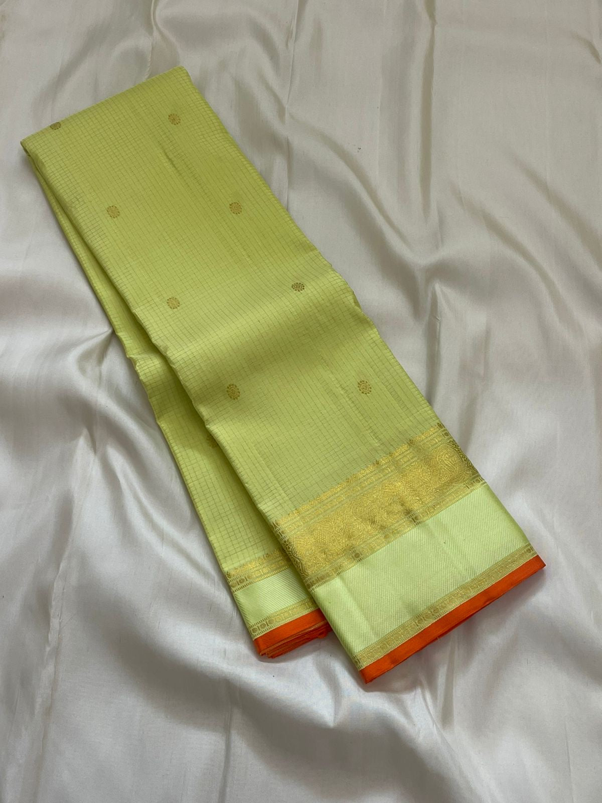 Meadow Shine — Kanchipuram Pure Silk Saree

Pastel meadow-green body with micro kattam checks & zari buttas

Antique zari borders woven with vine & elephant motifs

Warm kesari-orange selvedge a radiant edge . Silk mark cert￼. Free shipping within USA