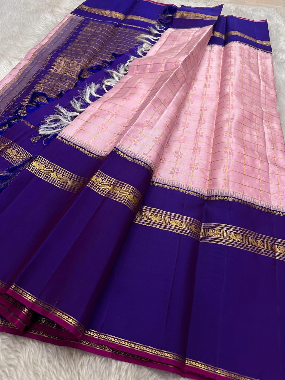 Anaar ✨ – Royal Purple & Lotus Pink Kanchipuram Pure Silk Saree
With Zari Kattam Checks, Mayil Motif Border & Grand Pallu
Korvai Contrast Weave in Regal Purple , 
Peacock & Floral Zari Panels, Raspberry Selvedge Finish
Silk Mark Certified