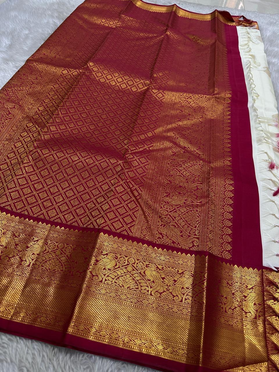 Ivory Mayil – White Mayil Butta Korvai Kanchipuram Silk Saree
Pure handloom silk | Ivory body with gold peacock buttas
Wine-maroon korvai border with peacock & floral zari motifs
Grand gold-zari brocade pallu | ships in two weeks
Silk Mark Certi