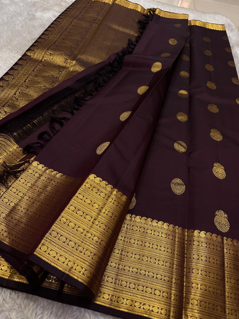 Cholai – Orchard at Dusk ✨ A pure Kanchipuram silk in deep purplish-brown, adorned with regal Gandaberunda 🦅 and delicate Kamalam 🌸 motifs. Its gold zari border layers Varisaipet, mango paisley 🥭, Rudhraksham, and Vanki for a true heritage masterpiece