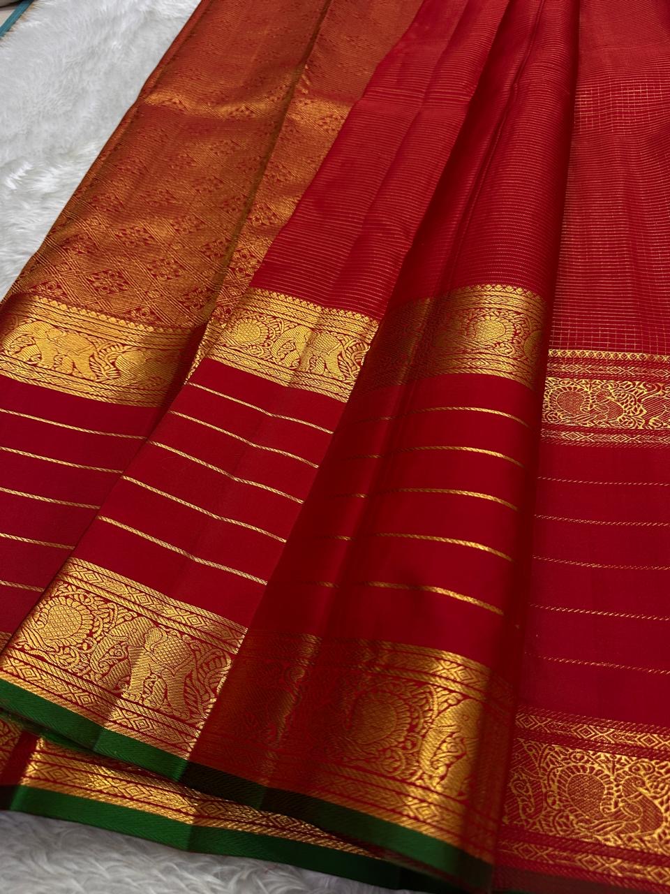 Kiran – Deep Red Kanchipuram Pure Silk Saree
Zari Checks with Delicate Buttas and Striped Rettapet Border
Richly Woven Pallu Accented by a bottle Green Selvedge
