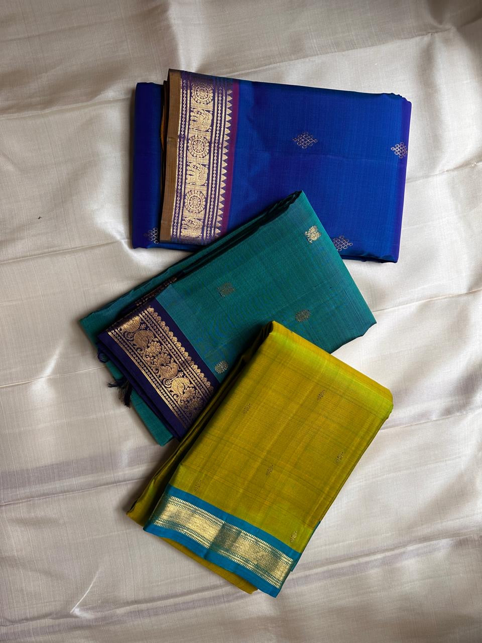Citrus and Teal – Pure Kanchipuram Silk Saree
Dual-tone body in parrot green and turmeric.
Elegant gold leaf buttas across the drape.
Teal korvai border
Rich teal pallu with diamond jaal and temple motifs.

Silk Mark Certified, delivery in 2 weeks