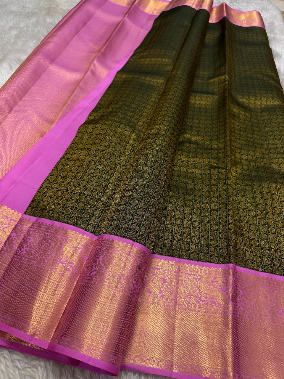 Iniya – Bottle Green & Pink Kanchipuram Pure Silk Saree with Floral Jaal and Mayil Border
Graceful and refreshing, Iniya is a handwoven masterpiece in bottle green with soft pastel pink accents. Delicate floral jaal and mayil motifs dance across the drape