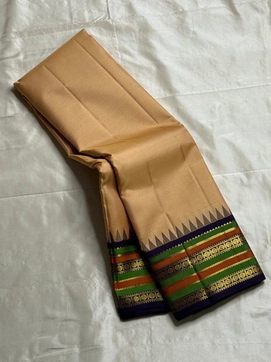 Sandal Temple – Pure Silk Kanchipuram Saree
Sandal Body with mild sheen , pillayar moggu   ✨
Indigo-Purple Korvai Border with Green & Ochre Stripes
Temple Gopuram Zari Edging & Grand Brocade Pallu
Silk Mark Certified | ships in two weeks