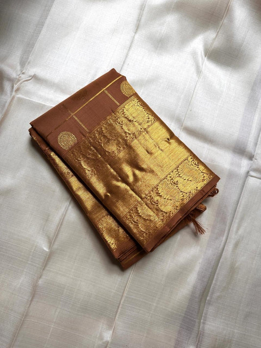 Bronze Chakram — Kanchipuram Pure Silk

Warm caramel-brown body with grid checks & “chakram” buttas

Grand gold zari peacock border & glowing pallu (kaddi + paisley vine)

Silk Mark Certified | Free Shipping within USA

Dispatch in 1 Week
