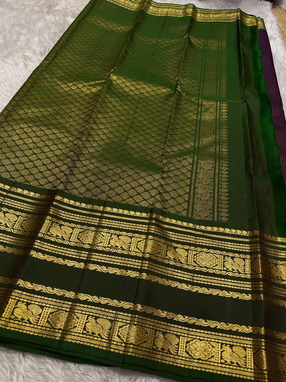 Radhe ✨
Plum Purple Oosi-Striped Kanchipuram Silk
Zari-Woven Yaali Motifs on the Body
Bottle-Green Rettapet Border with Peacocks
Grand Gold Zari Jaal Please | Silk Mark Certified