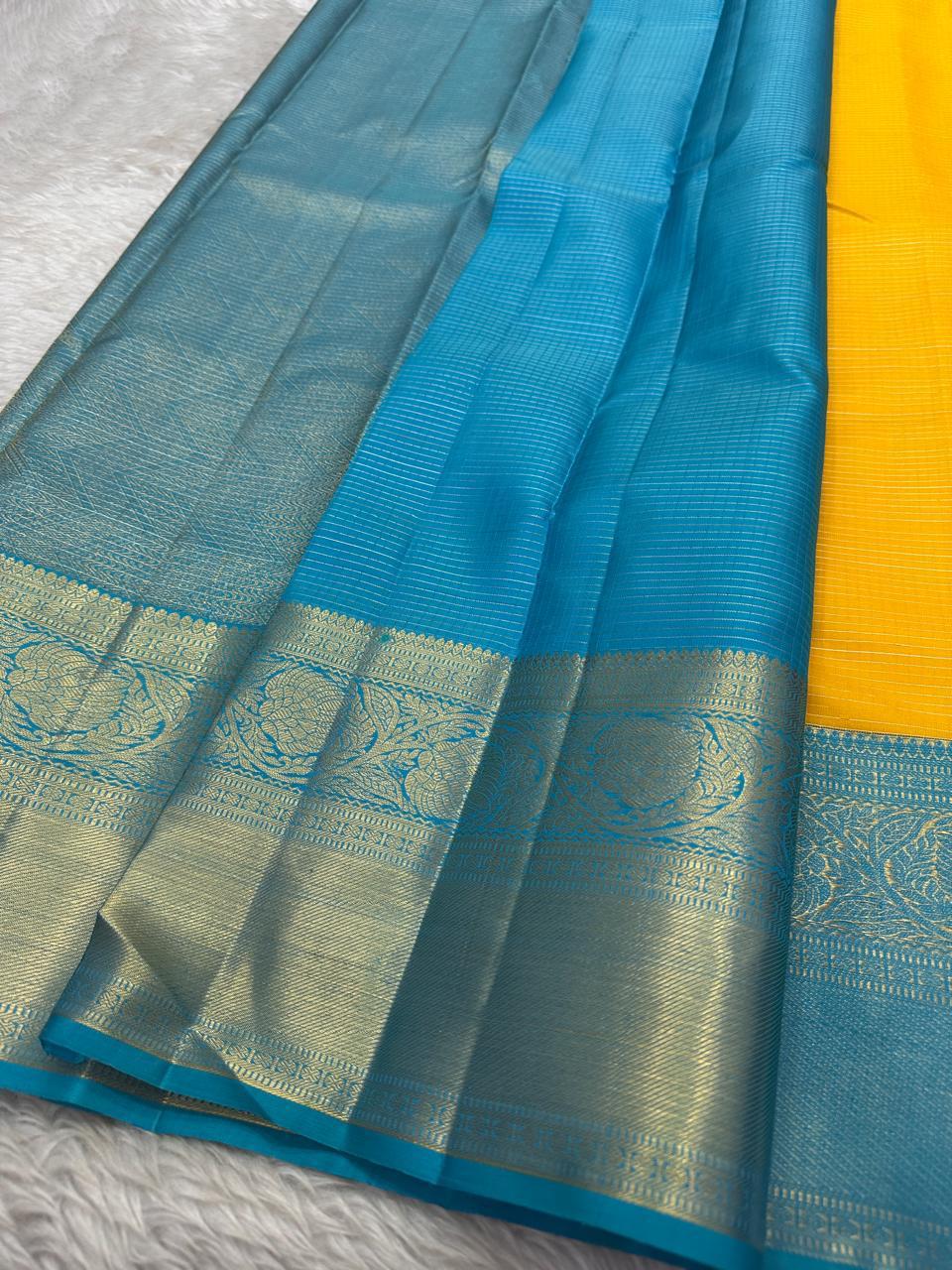 This radiant yellow pure silk drape is elevated by an exquisite and unexpected pairing — a serene sky blue border, making it both eye-catching and rare. Fine zari checks shimmer gently across the body, timeless bavaanji border