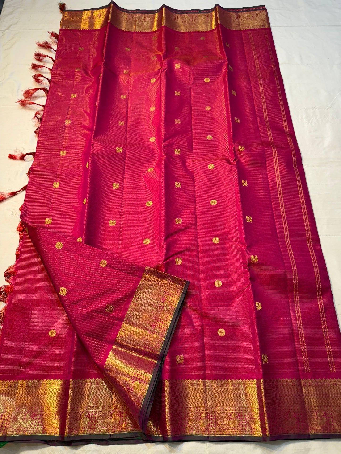 Vairaoosi Rani Mayil Chakram — Pure Kanchipuram Silk Saree
Rani-pink body with gold chakram buttas & korvai mayil zari border in dark green selvedge ✨
Silk Mark Certified • Free Shipping within USA • Ships in Two Weeks