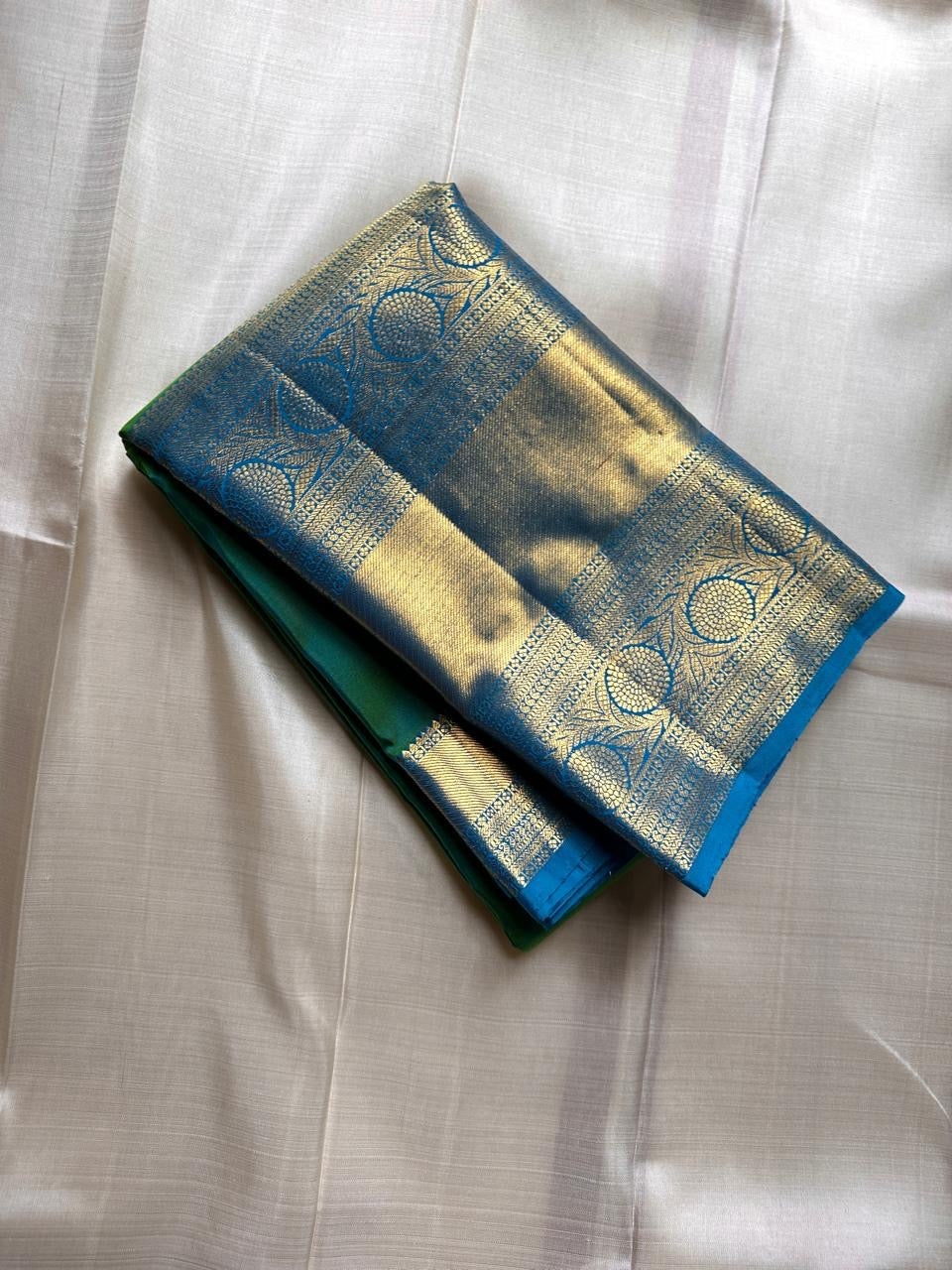 Parrot green Kanchipuram silk saree with sky blue zari border, folded view