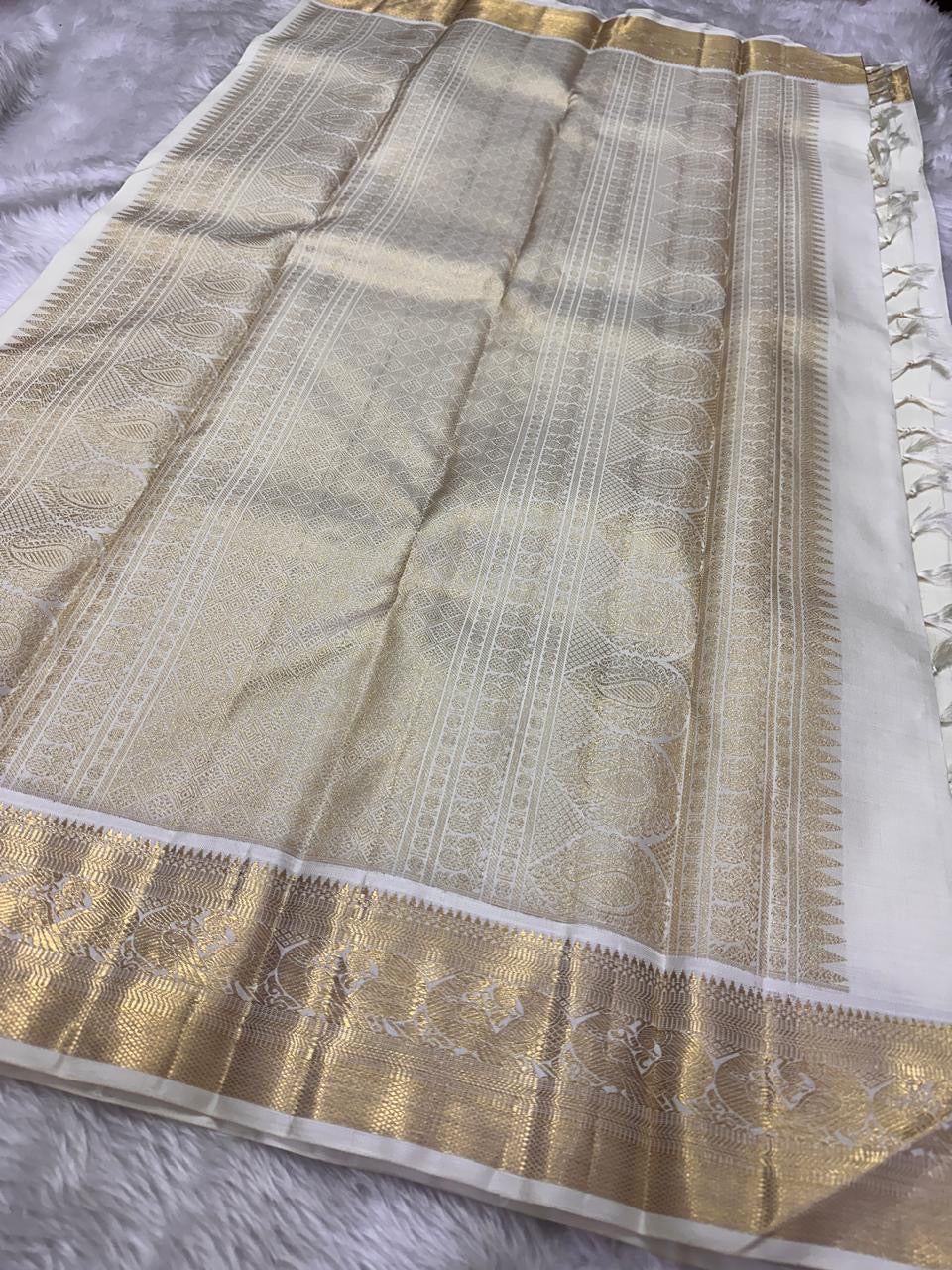Pearl Radiance ✨ – Pure Kanchipuram Silk Saree
Ivory Body with Gold Zari Buttas & Medallions
Traditional Yali & Peacock Motif Zari Border
Grand Zari Pallu with Paisleys & Floral Vines
Silk Mark Certified | Free USA Shipping