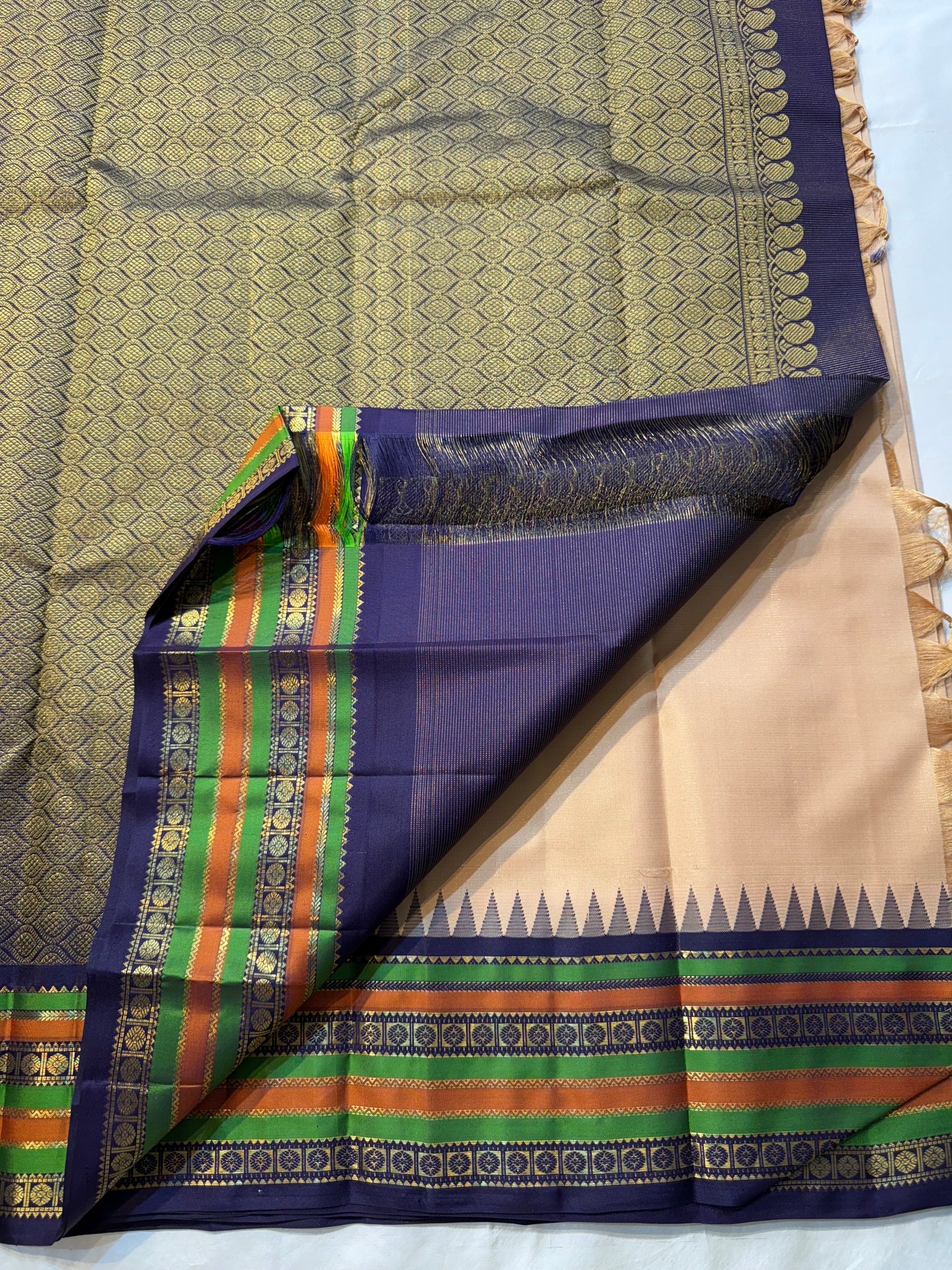 Sandal Temple – Pure Silk Kanchipuram Saree
Sandal Body with mild sheen , pillayar moggu   ✨
Indigo-Purple Korvai Border with Green & Ochre Stripes
Temple Gopuram Zari Edging & Grand Brocade Pallu
Silk Mark Certified | ships in two weeks