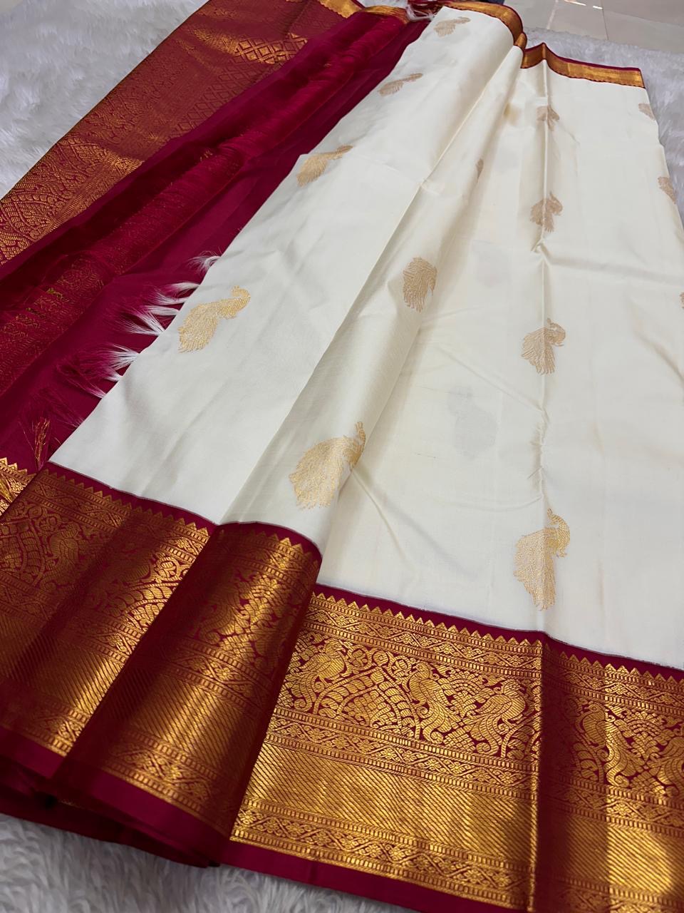 Ivory Mayil – White Mayil Butta Korvai Kanchipuram Silk Saree
Pure handloom silk | Ivory body with gold peacock buttas
Wine-maroon korvai border with peacock & floral zari motifs
Grand gold-zari brocade pallu | ships in two weeks
Silk Mark Certi