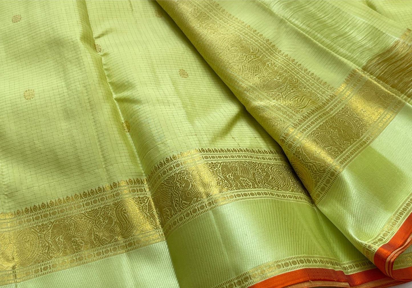 Meadow Shine — Kanchipuram Pure Silk Saree

Pastel meadow-green body with micro kattam checks & zari buttas

Antique zari borders woven with vine & elephant motifs

Warm kesari-orange selvedge a radiant edge . Silk mark cert￼. Free shipping within USA
