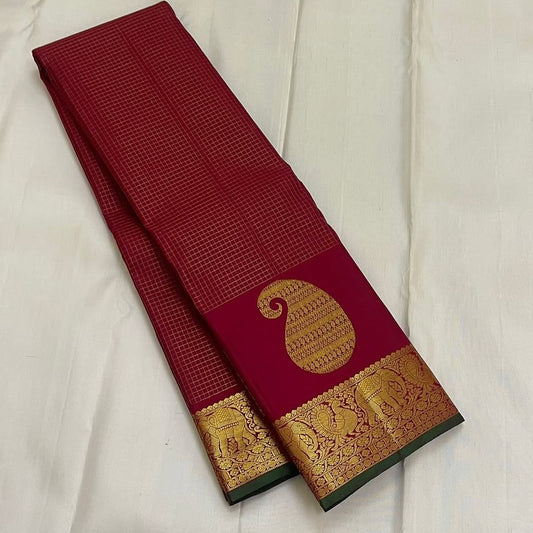 Ushas, Deep Arakku Red Pure Kanchipuram Silk Saree
Radiant Oosi Kattam body with ornate Paisley 2gm Zari
Vanasringaram,Muthuseer,Kamalam border with Fishpettu detailing
Exquisite diamond-pet grid Zari pallu, richly finished with a bold deep green selvedge