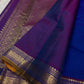 Sapphire Orchid celebrates the classic blue–purple pairing of Kanchi. The body is a rich sapphire/cobalt blue with tiny floral buttas in gold zari. A striking amethyst-purple korvai border and grid pavun Zari pallu Silk Mark Certified, delivery in 2 weeks