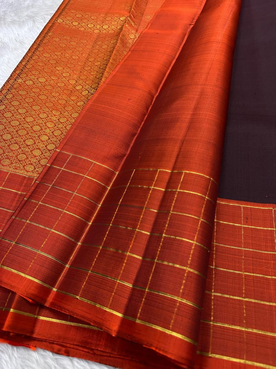Minmini – Deep brown Pure Kanchipuram Silk Saree with Gold Zari Buttas, Vibrant Orange Checked Border in Zari Kattam Weave & Ornate Gold Brocade Pallu with Traditional Motifs